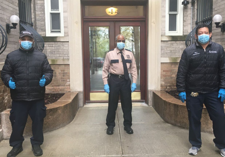 three men with face masks in front of residential building