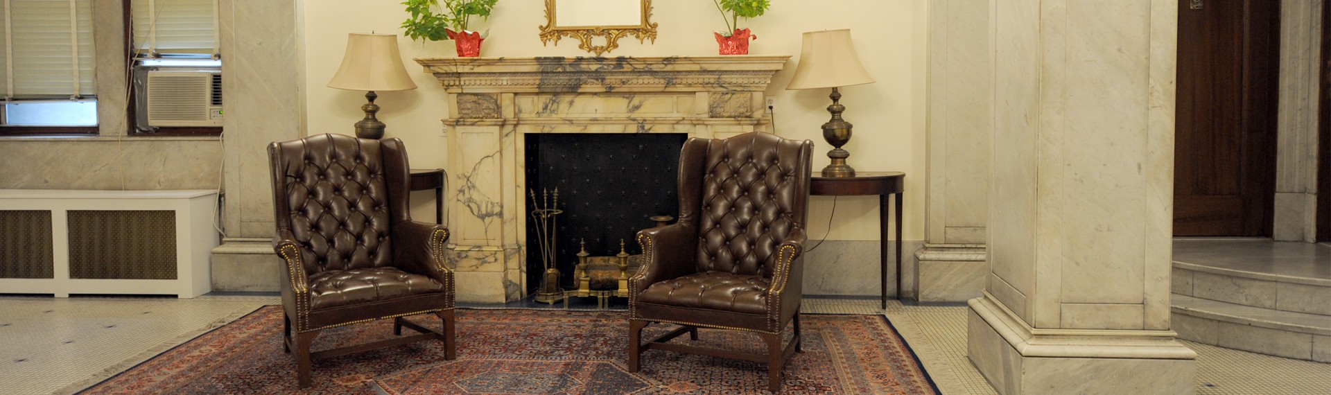 Lobby inside of 423 W. 120th Street with a decorative fireplace and furniture 