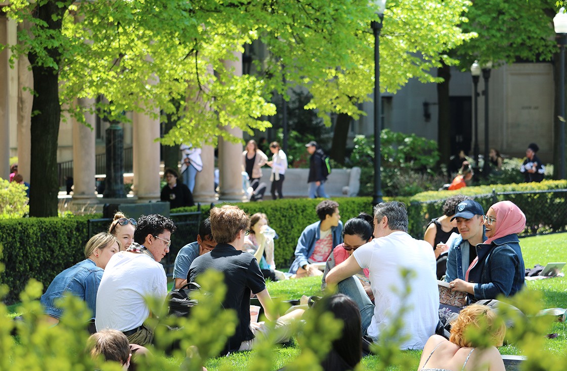 Students relaxing on lawn next to Hamilton Hall