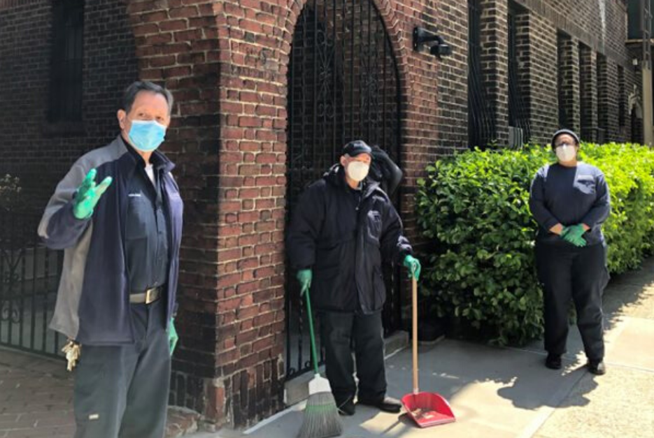 Two men and one woman with masks in front of residential building