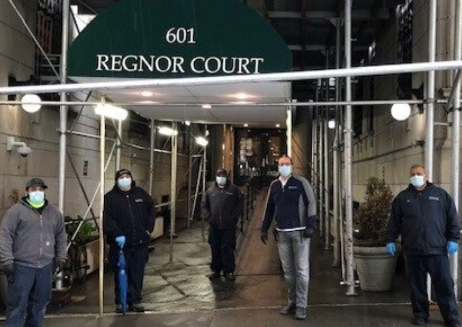 five residential staff members wearing face masks in front of residential building