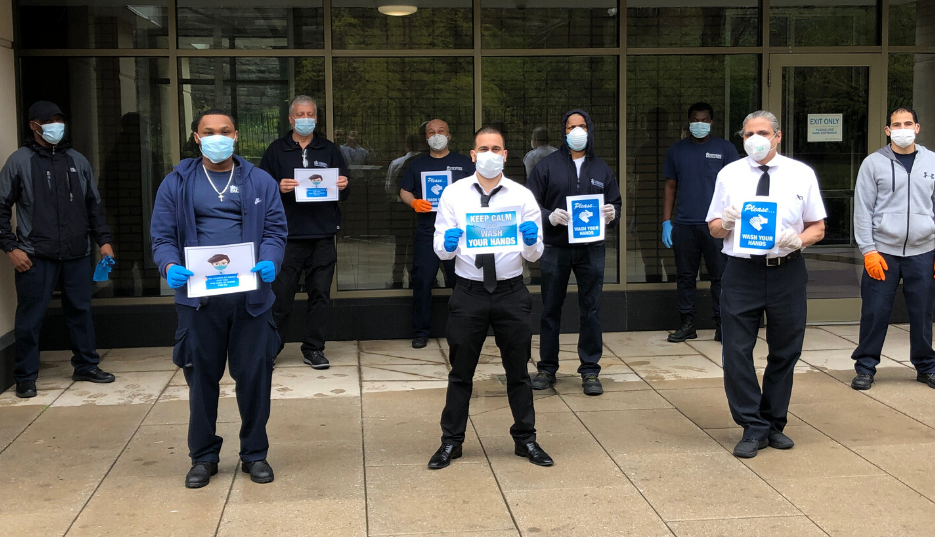 nine residential staff members wearing face masks in front of residential building