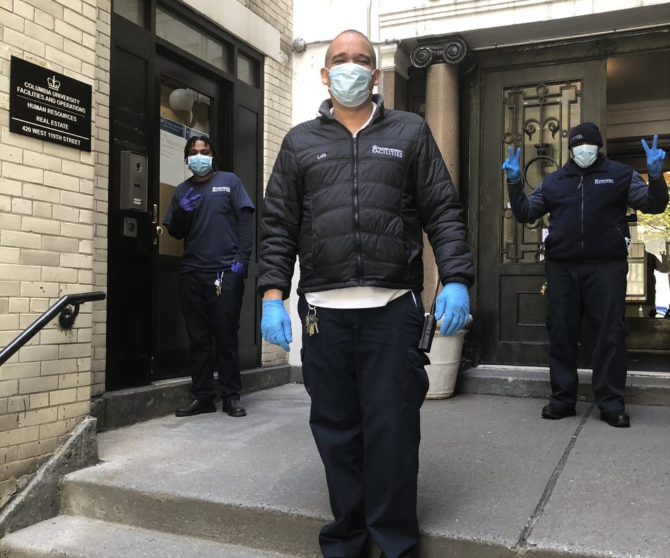 three residential staff members wearing face masks in front of residential building