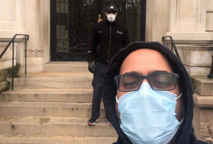 two men with masks in front residential building