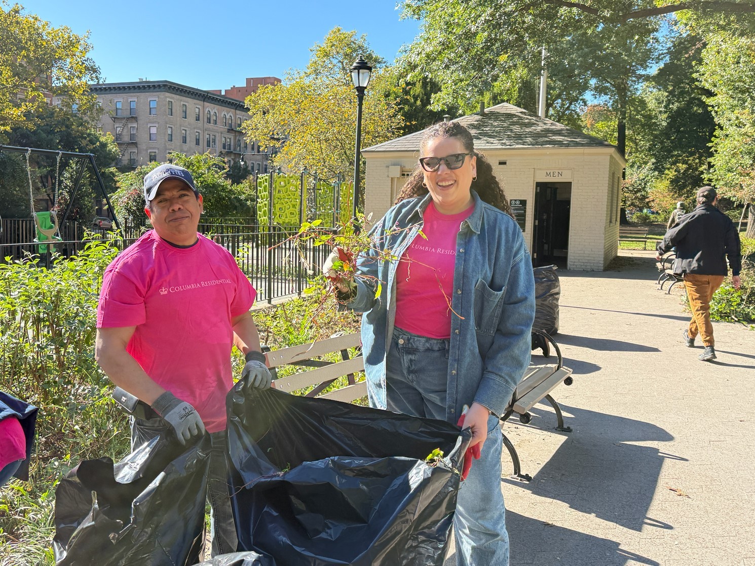 Residential employees posing for a photo while putting weeds in trash bags