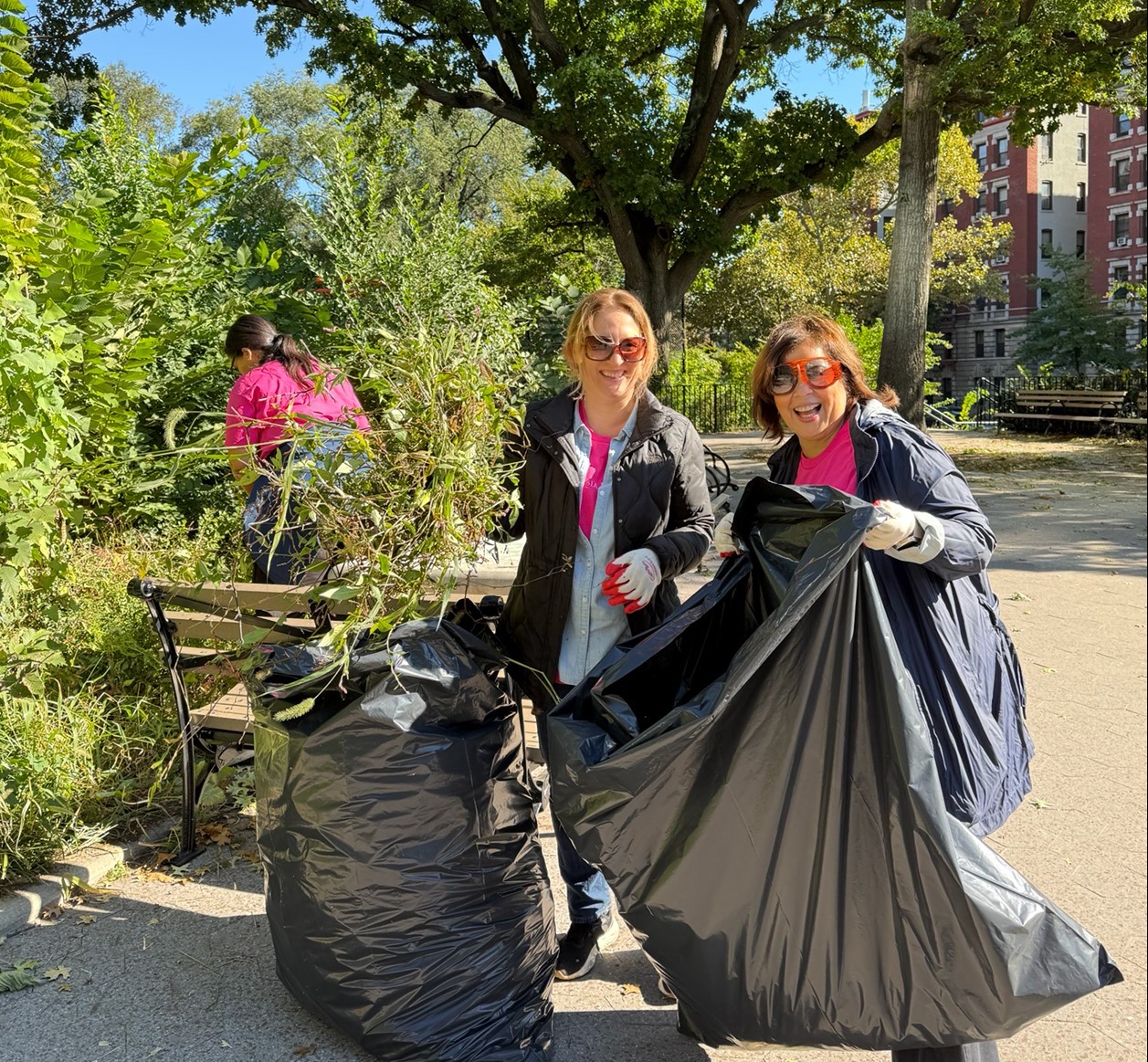 Residential employees posing for a photo while putting weeds in trash bags