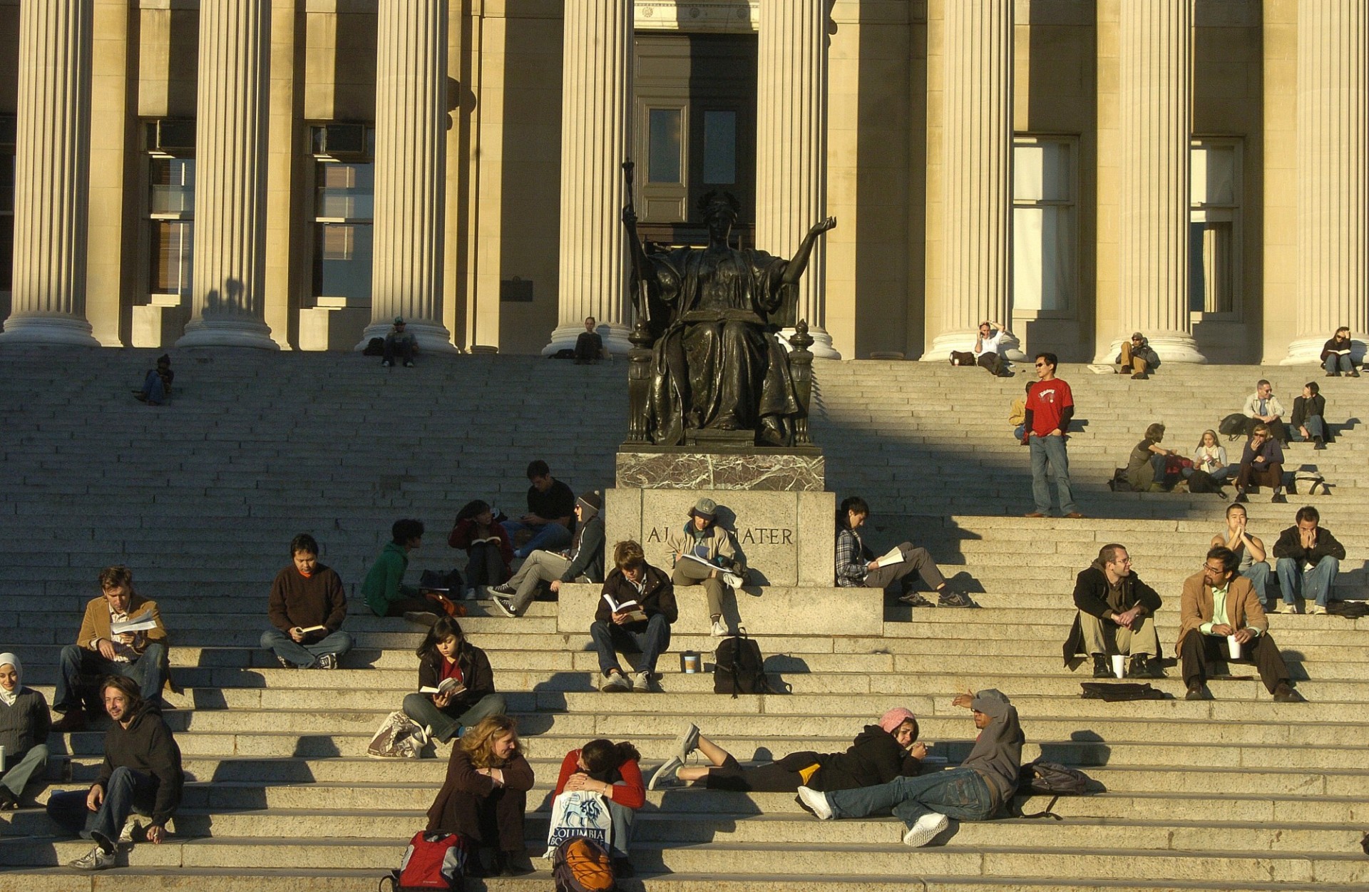 photo of students sitting on the steps of Low Library near Alma Mater