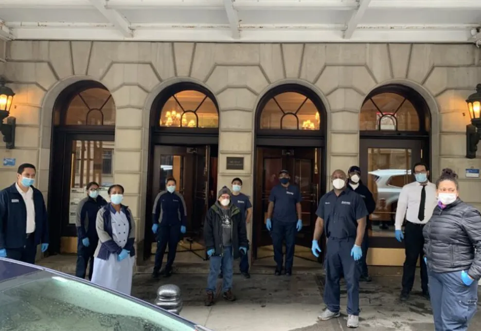 eleven men and women with face masks in front of residential building