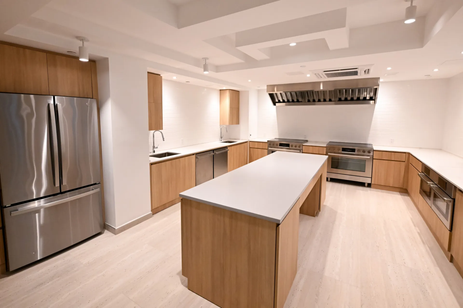 Ground floor common kitchen showing refrigerator, stoves, island, cabinets. Credit: Diane Bondareff