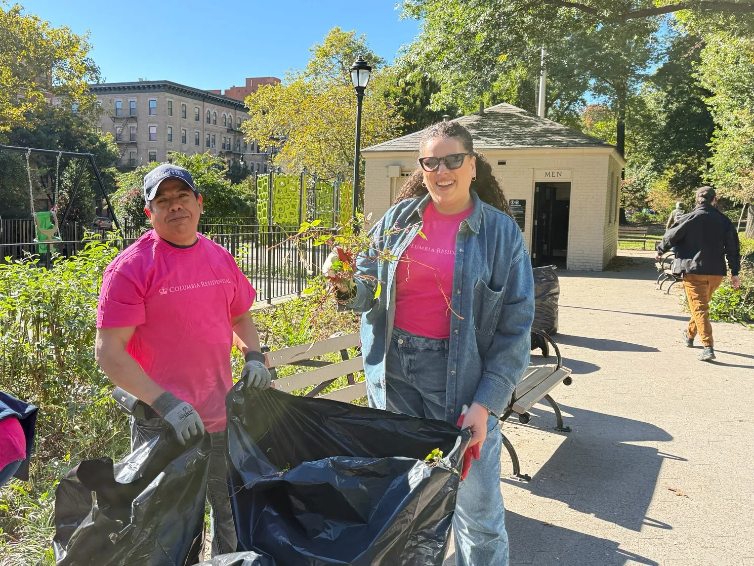 Residential employees posing for a photo while putting weeds in trash bags
